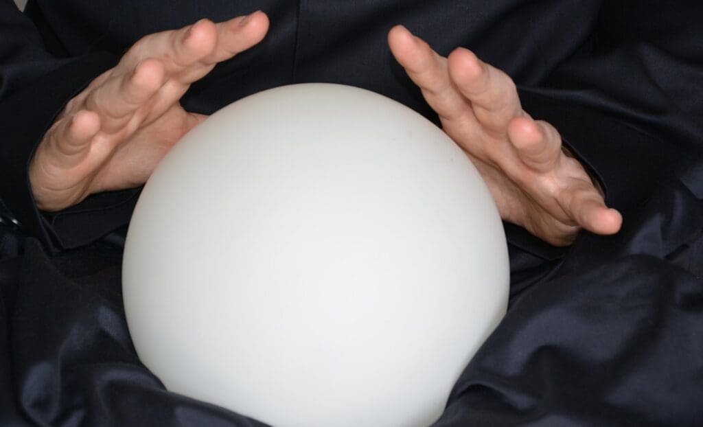 A person holding their hands over the top of a white ball.