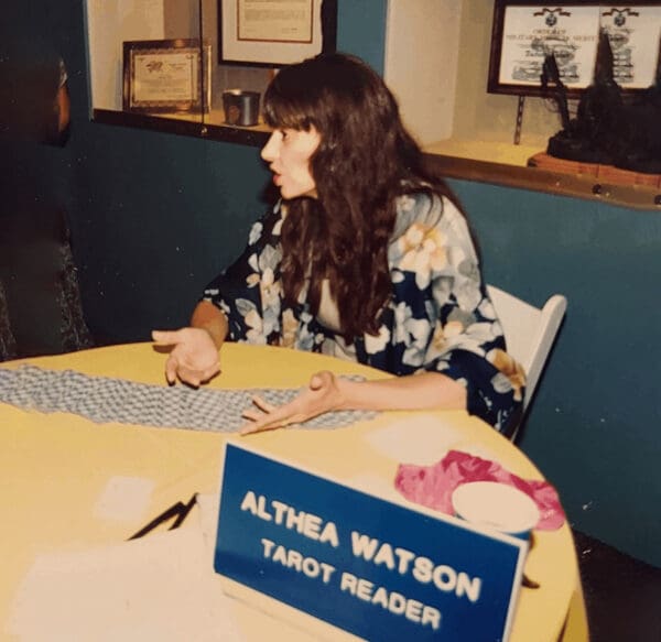 A woman sitting at a table with papers on it.