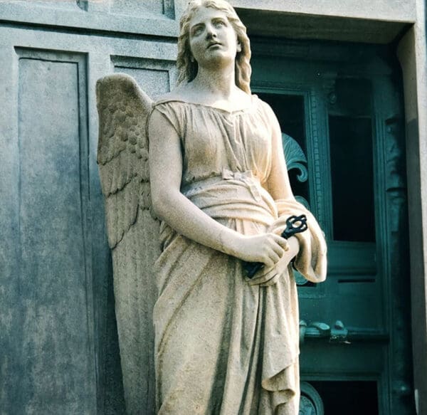 A statue of an angel in front of a door.