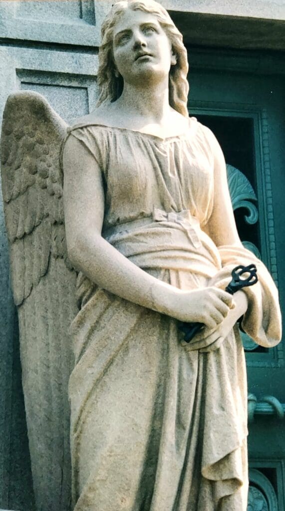 A statue of an angel holding a pair of scissors.